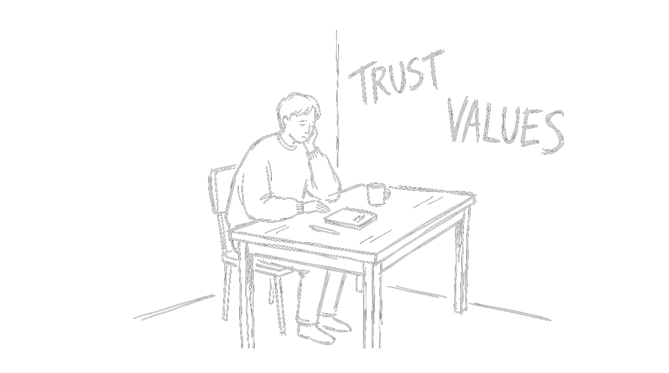 A person alone at a desk with TRUST and VALUES written on the wall behind them